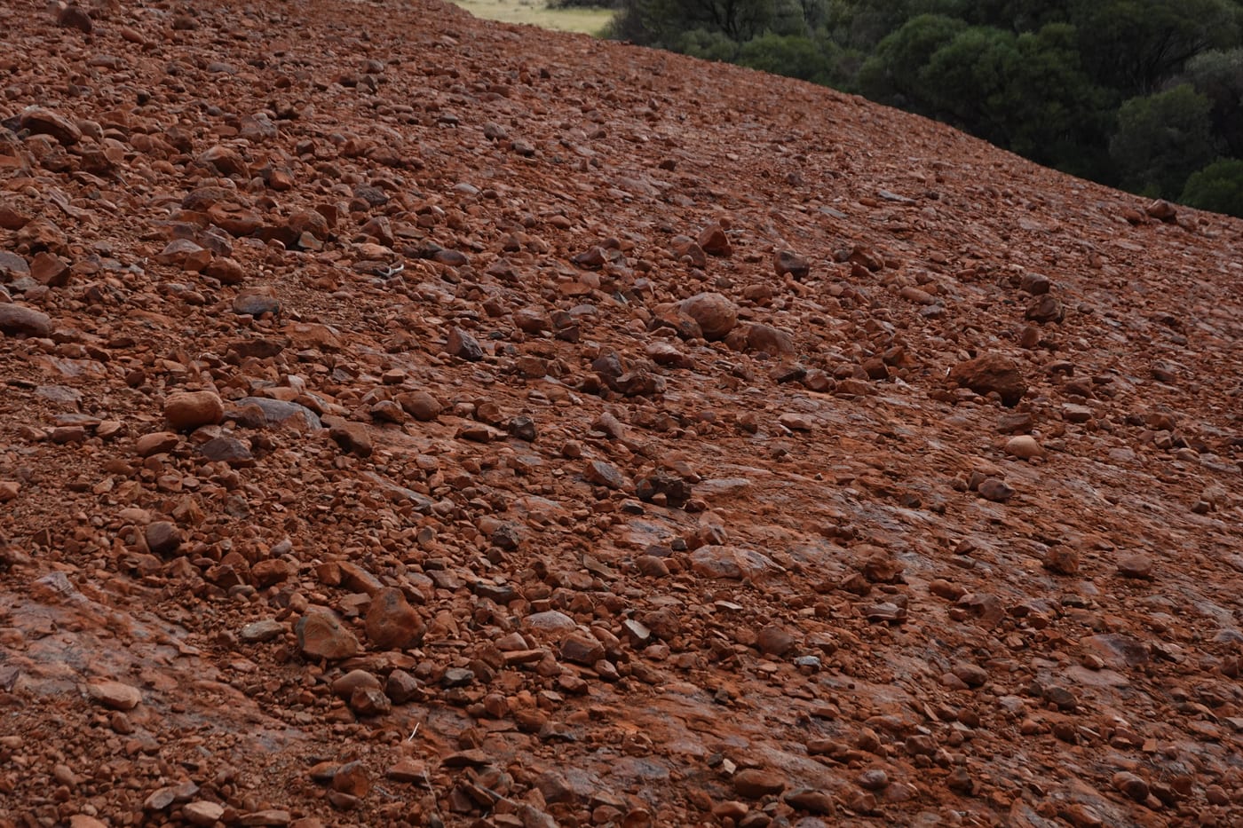 Red scree slope below a dome.