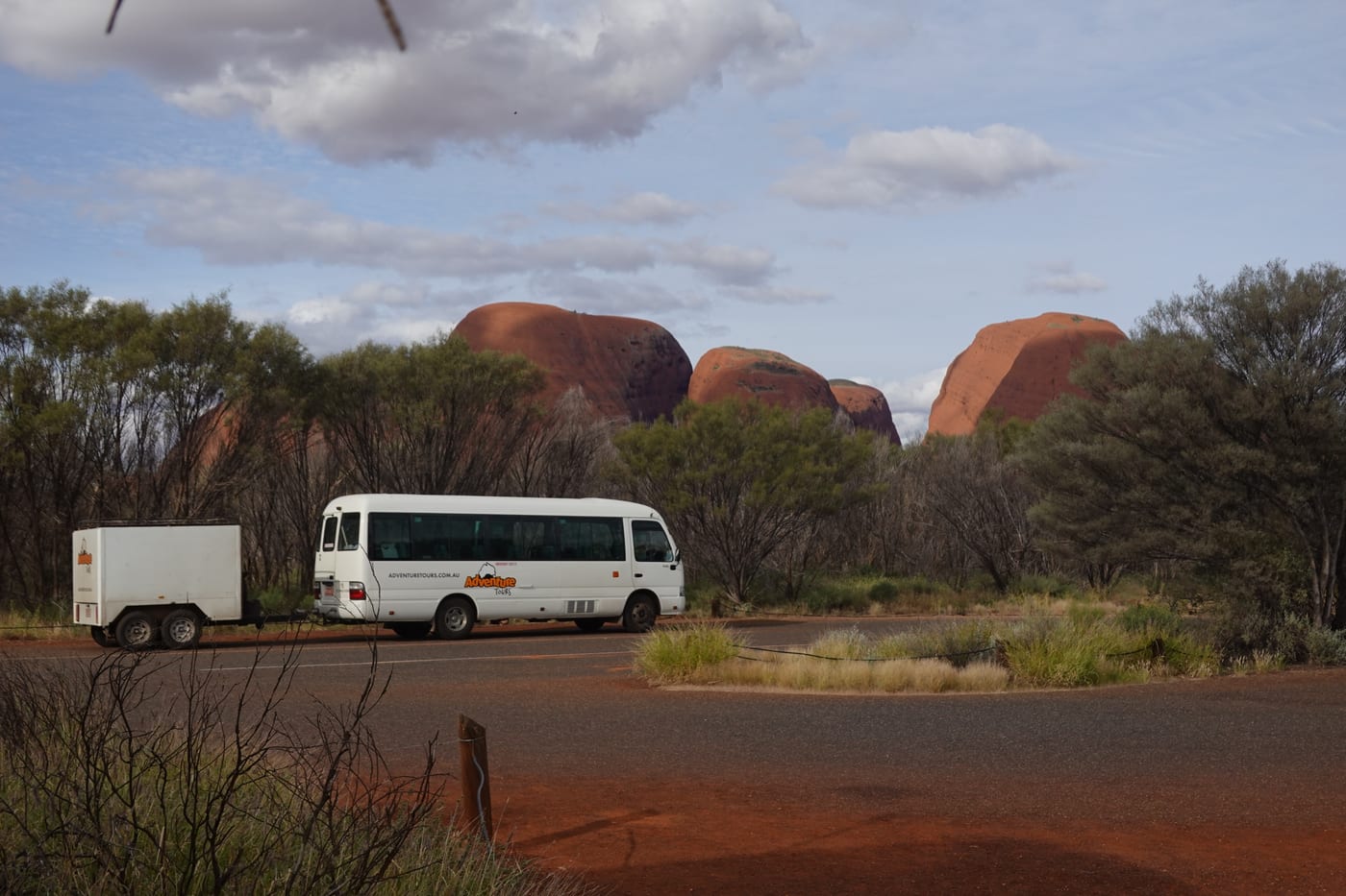 Tour bus with Kata Tjuta in the background.