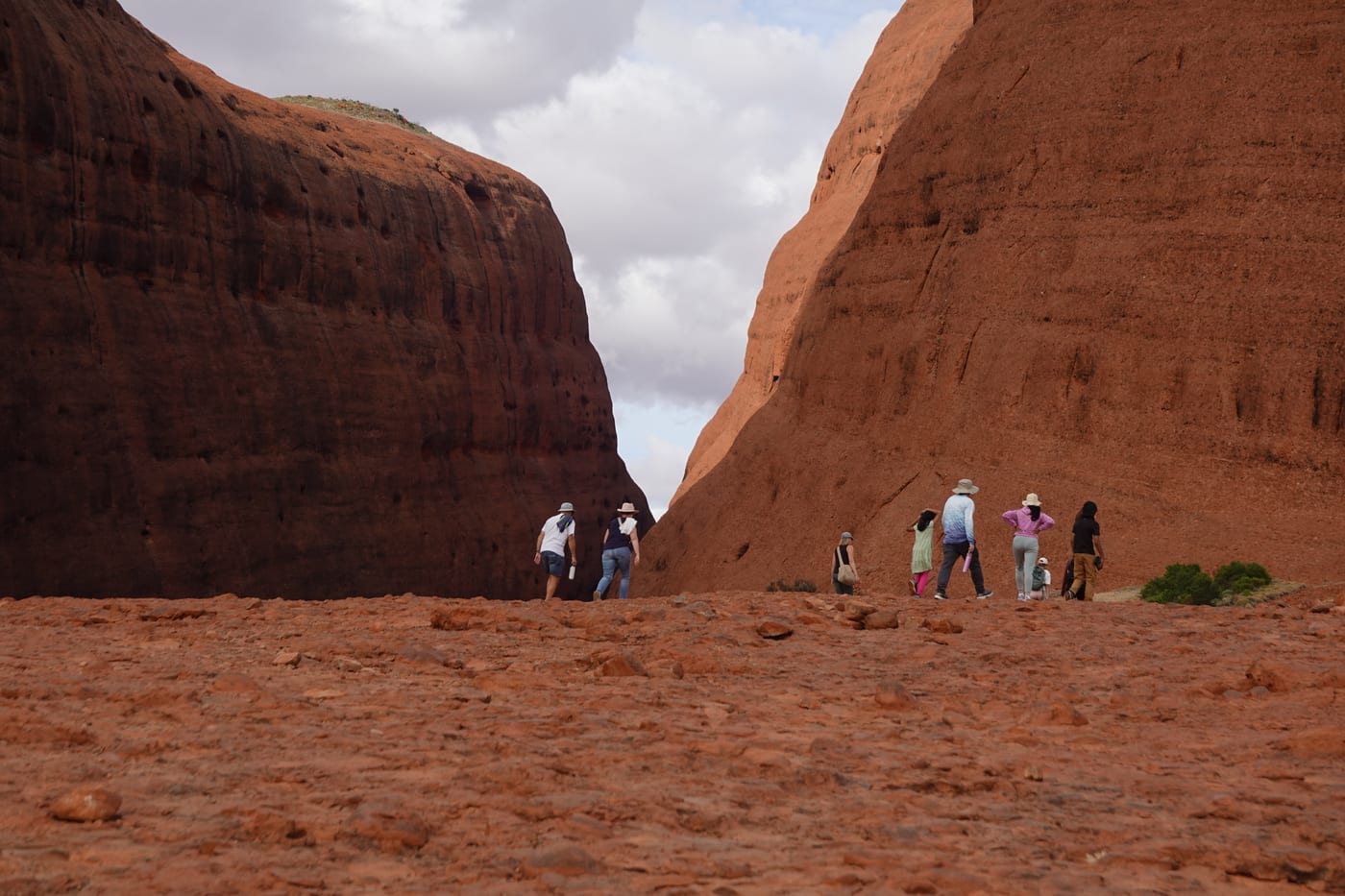 Hikers walking between two domes at the entry.
