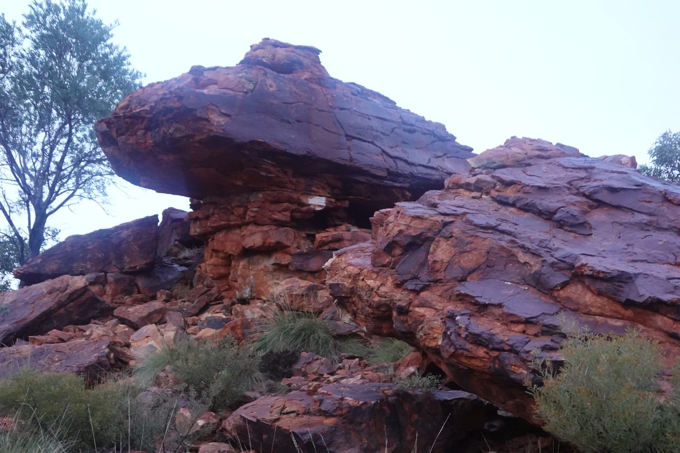 A large boulder balanced on the trailhead at dawn.