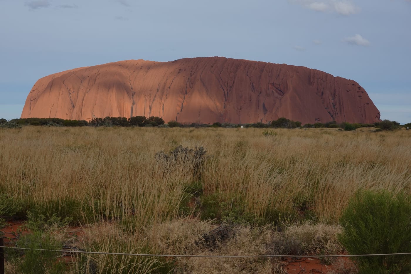 Uluru glowing red at sunset.