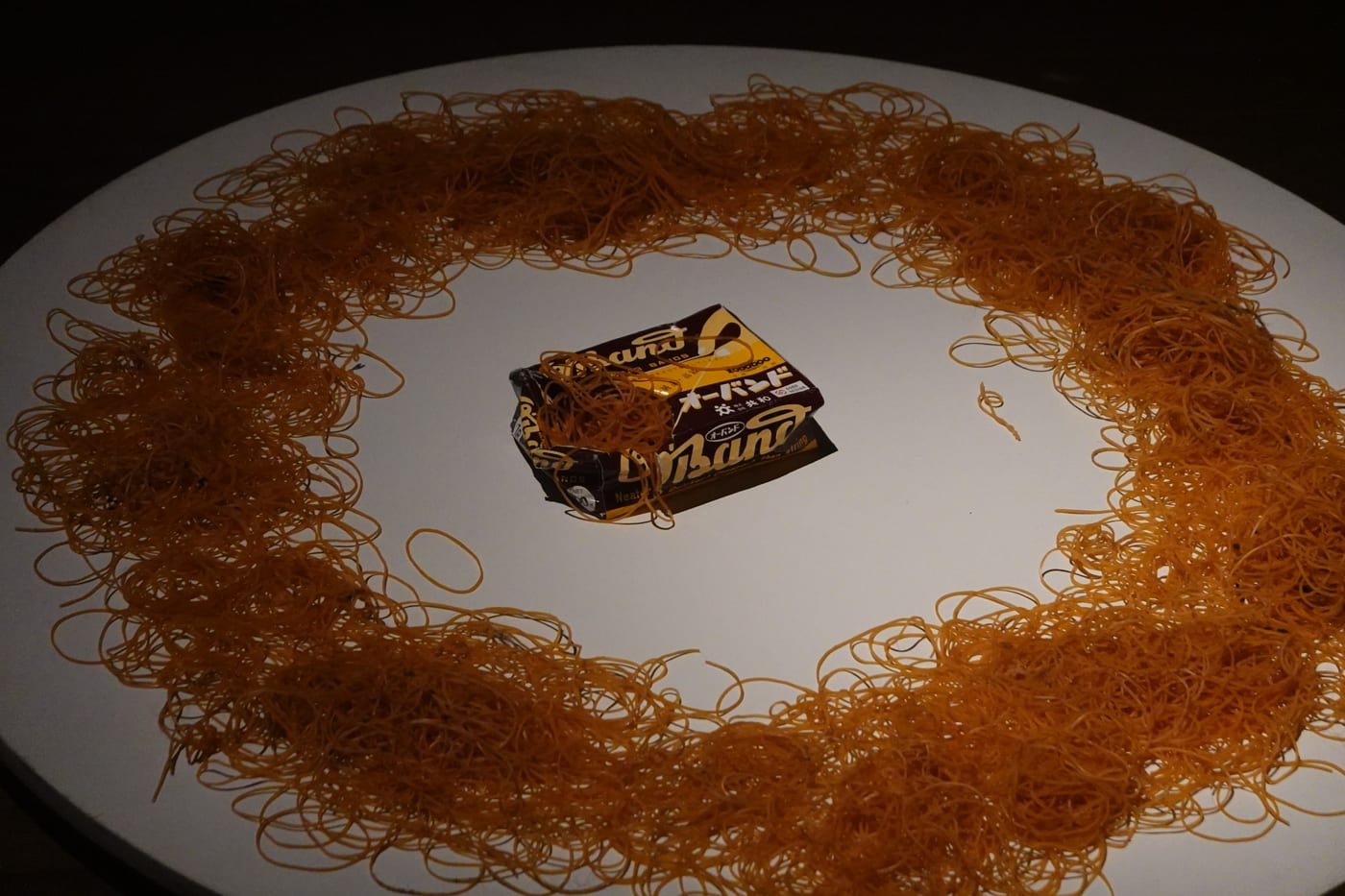 Tangle of rubber bands on a pedestal.