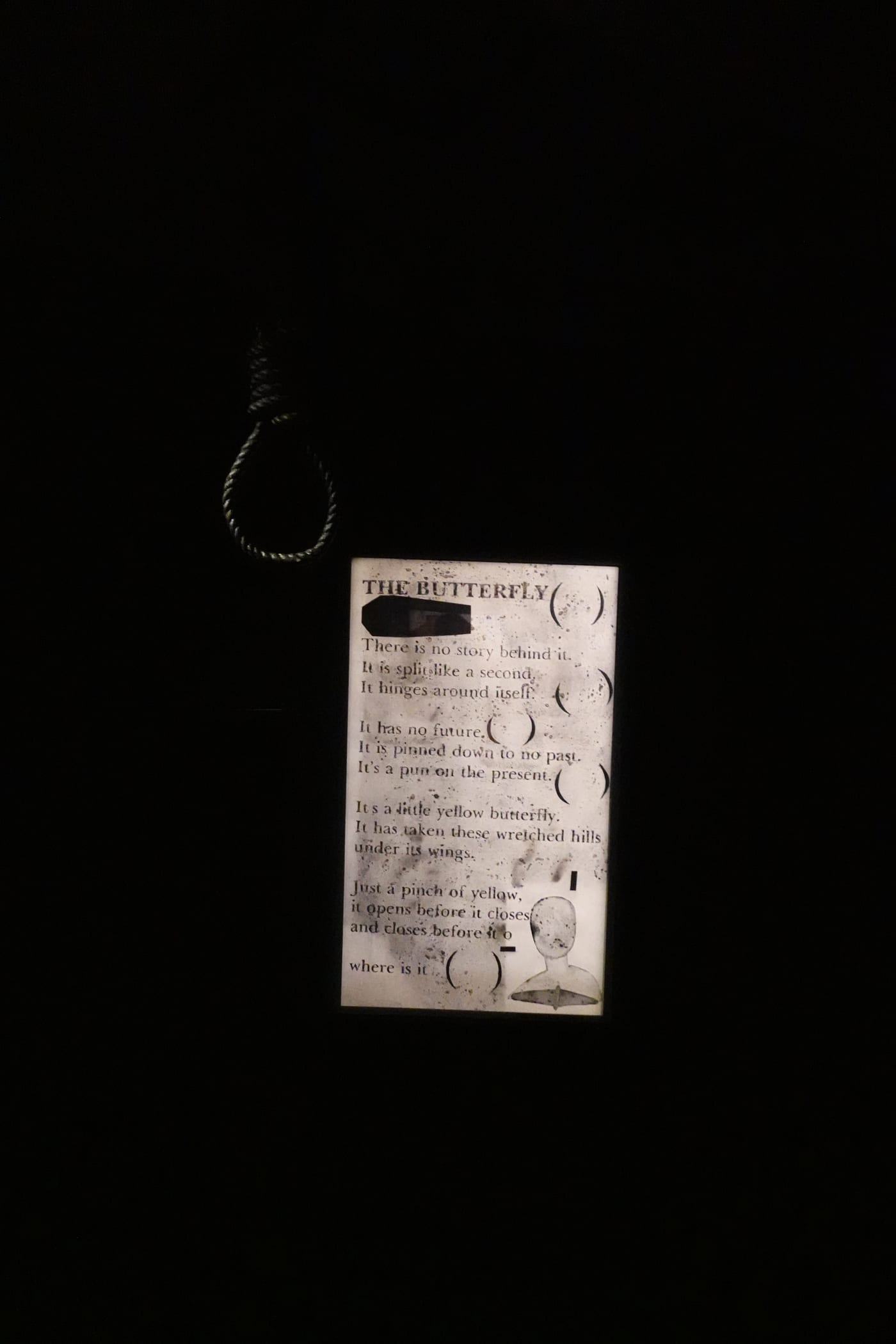 Illuminated 'The Butterfly' text piece in a dark room.